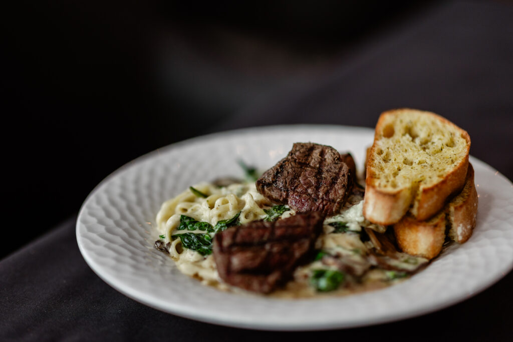 Filet medallions with spinach, mushrooms, pasta, and blue cheese Alfredo sauce.
