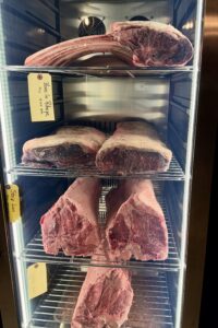 Tomahawks and Prime short loins aging inside the Cellar & Flame dry-aging cabinet in Traverse City.
